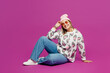 © ViDi Studio - Full body side view young smiling cool happy lesbian woman she wear pink animal clothes sits look camera isolated on plain purple background studio portrait. Pride day June month love LGBTQ concept