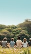 © Mind - Group of people enjoying nature, sitting together outdoors with a scenic view of lush green mountains and a clear blue sky in the background.
