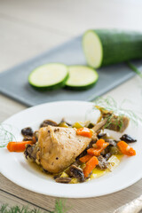 Wall Mural - roast chicken with mushrooms and vegetables in a plate on a wooden table