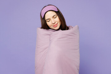 Poster - Young happy calm woman wear pyjamas jam sleep eye mask, wrapped in duvet rest relax at home, close eyes isolated on plain pastel light purple background studio portrait. Good mood night nap concept.