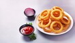 © HeyRix - Homemade crunchy deep fried onion rings in plate with sauce