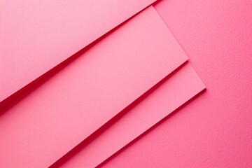 Poster - A flat lay of three pink paper sheets arranged at an angle, creating geometric shapes on the solid color background. The sheets have sharp edges and a glossy finish, adding to their elegance. 