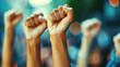 © Uwe - Close up of multiethnic people's hands raising fists in the air, with strong wrists showing the spirit of struggle and solidarity