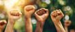 © Uwe - Close up of multiethnic people's hands raising fists in the air, with strong wrists showing the spirit of struggle and solidarity
