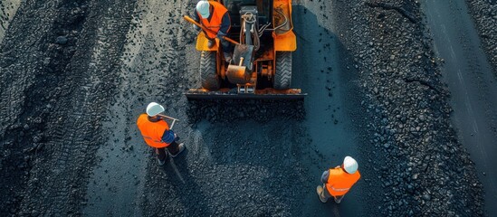 Construction Workers Leveling Asphalt with a Grader