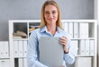 © H_Ko - Business woman holding a writing tablet clipboard folder in the office