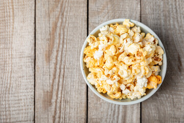Wall Mural - Tasty popcorn on wooden background. Cinema and entertainment concept. Movie night with popcorn.Cheese and caramel popcorn. Delicious appetizer, snack. Place for text. Copy space.Banner