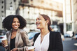 © peopleimages.com - Women, business people and happy in city for commute, partners and laughing together on street. Female friends, talking and walking to work for bonding, coffee break and funny story or gossip