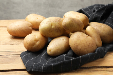 Canvas Print - Pile of fresh potatoes on wooden table, closeup