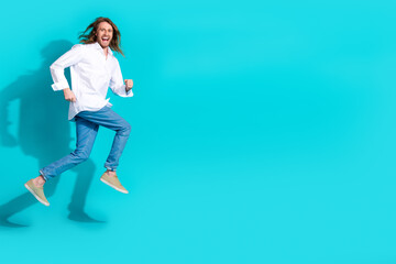 Wall Mural - Full length photo of handsome good mood guy wear white shirt jumping high running emtpy space isolated blue color background