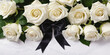 © Lisa - Bouquet of elegant white roses with black funeral ribbon and bow on a white table. Background for banner with symbol of mourning or grief. Funeral ceremony, remembrance and farewell. Top view.