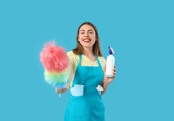 Sticker - Young woman with bottle of detergent and pp-duster on blue background