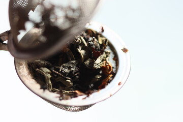 Aufkleber - A metal strainer filled with dried herbs, perfect for use in cooking or as a decorative item.