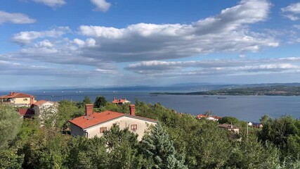 Wall Mural - A beautiful view of a town with a large body of water in the background. The houses are small and the sky is cloudy