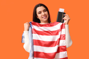 Poster - Beautiful young happy woman with USA flag, passport and ticket on orange background