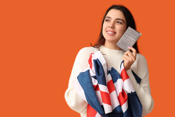 Poster - Beautiful young happy woman with UK flag and passport on orange background