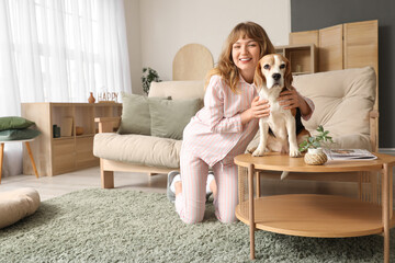 Wall Mural - Young woman with cute beagle dog on coffee table at home