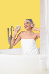 Sticker - Young woman in bathtub with loofah and bathroom curtain on yellow background