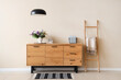 © Pixel-Shot - Vase with lilacs on wooden chest of drawers, ladder and lamp in stylish room