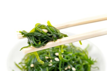 Wall Mural - Chopsticks over chuka salad with seaweed on white background