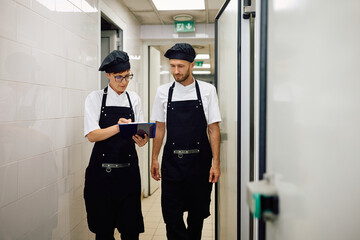 Wall Mural - Two chefs analyzing menu while working in restaurant.