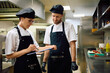 © Drazen - Two professional chefs going through order list and working in restaurant.