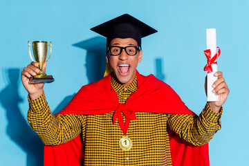 Poster - Photo of attractive young man hold diploma golden goblet graduation hat dressed stylish plaid clothes isolated on blue color background