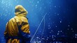 © stocker - A fisherman stands alone in the rain, his yellow raincoat glistening in the downpour.