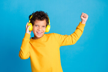 Poster - Photo portrait of small charming boy headphones winning dance wear trendy yellow outfit isolated on blue color background