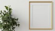 © AkuAku - Gold frame mockup on white wall with houseplant for artwork display
