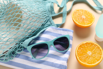 Poster - String bag, different beach accessories and orange on beige background