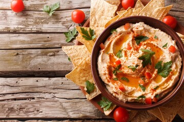 Canvas Print - Top view of hummus and nachos on wooden table