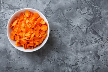 Sticker - Top view of organic carrot chips in white bowl on gray background Overhead shot with copy space