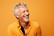 © Stocknterias - Portrait of a handsome mature man laughing, isolated on orange background