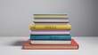 © Mr. B - This image displays a stack of various colored books arranged on a plain gray surface, epitomizing knowledge, education, and the colorful realms of literature and learning.