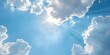 The sun shines through blue skies with clouds creating abstract shapes. Concept Nature, Weather, Sky, Sun, Clouds