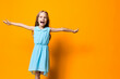 © SHOTPRIME STUDIO - Joyful little girl in blue dress leaping with happiness against vibrant orange background
