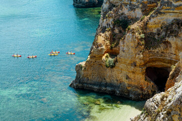 People group with kayaks and blue water..Rocky clifs of Ponta da Piedade at Lagos, Portugal.