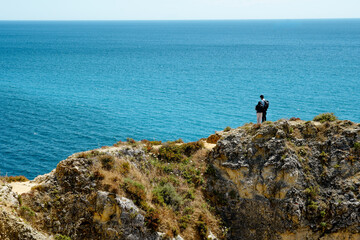 a couple hugs on a cliff..Rocky clifs of Ponta da Piedade at Lagos, Portugal. Ocean beautiful landscape cliffs