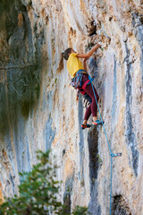 Wall Mural - rock climber girl. rock climbing as an Olympic sport. strong girl. A girl climbs a rock.