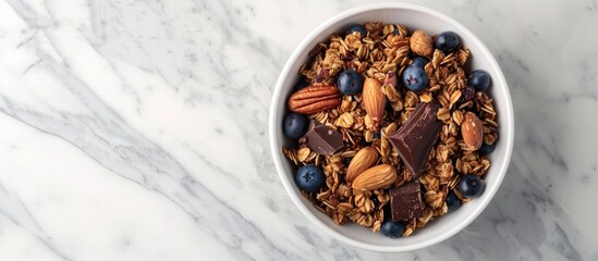Aufkleber - Granola, dark chocolate, nuts, blueberries in a bowl placed on a white marble surface providing a healthy breakfast option. Seen from top with space for text in the image. with copy space image