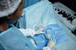 © Seventyfour - High angle view of medical assistant covering surgical site with draping in operating room copy space