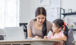© David - Asian business lady working on computer while her daughter hugging her