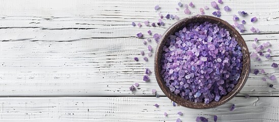 Poster - A bird's-eye view of lavender sea salt crystals in a bowl on a white wooden surface, offering space for other elements in the image. Copy space image. Place for adding text and design