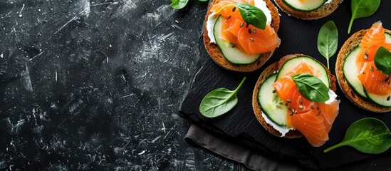 Wall Mural - Top view of delicious salmon, cream cheese, and cucumber toasts on a black table with ample copy space image.