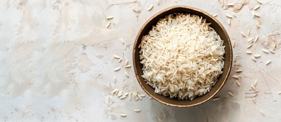 Poster - Top view of a bowl of boiled rice on a light background with ample copy space image.