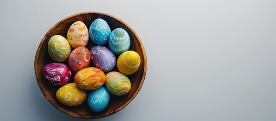 Aufkleber - Closeup of brightly colored Easter eggs arranged in a wooden bowl on a white background with space for adding text or design elements - copy space image.