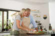 © DoneDeal/peopleimages.com - Mature couple, happy and cooking in kitchen for vegetable nutrition, vegan cuisine and diet for health. Smile, man and woman with food to prepare lunch, bonding together and white wine glass in home