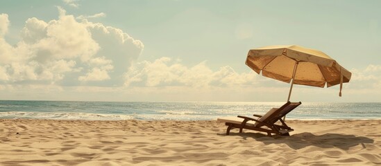Aufkleber - A chaise longue on a sandy beach with an umbrella, set against the sea and sky, offering copy space image.
