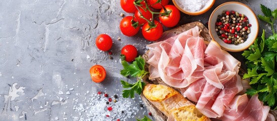 Aufkleber - Selective focus on delicious sliced ham, cherry tomatoes, parsley, salt, and baguette arranged on a wooden grey table with copy space image.